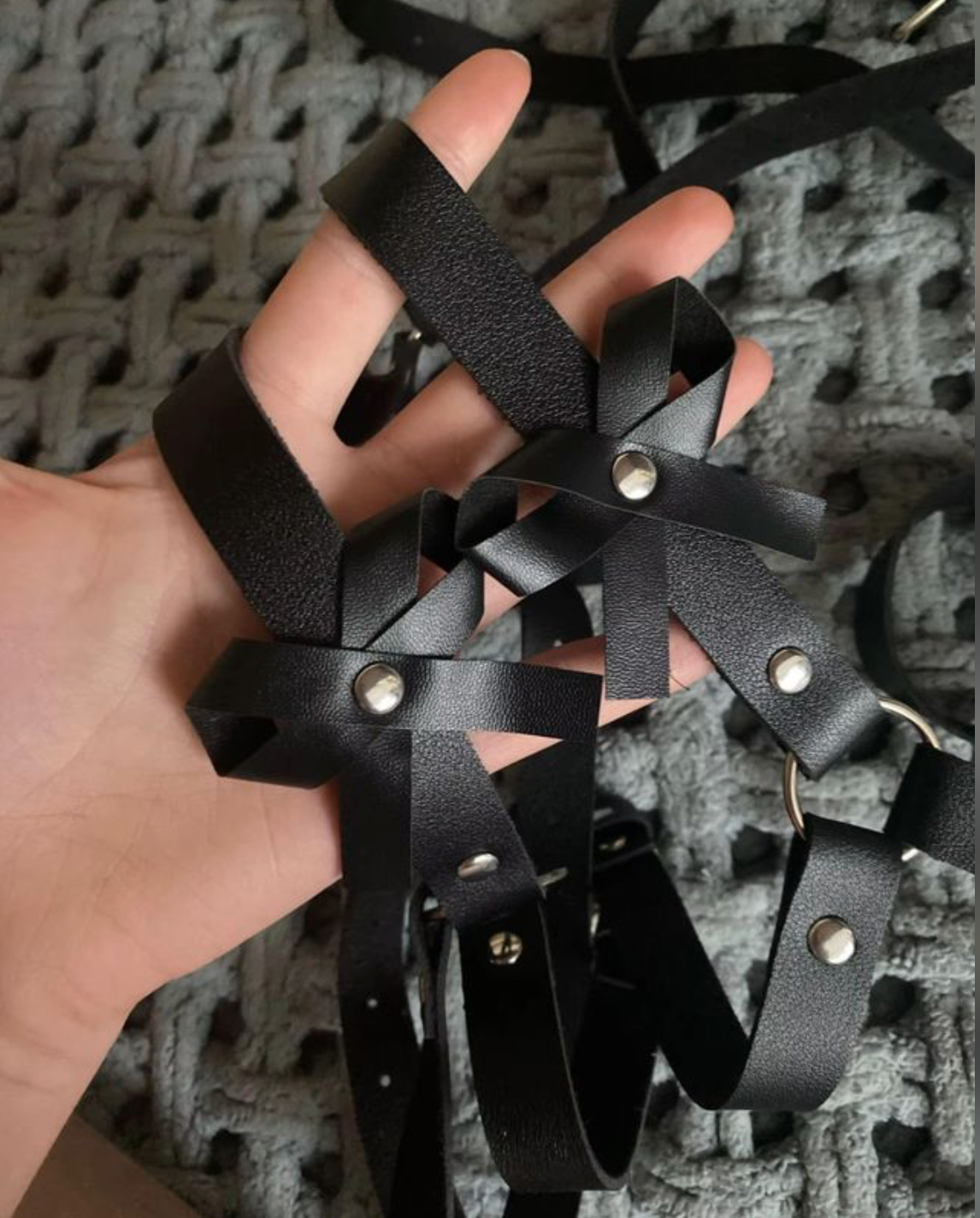 Black adjustable body harness with decorative bow accents shown in a close-up product view.
