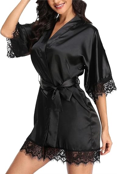 Woman wearing a black satin robe with elegant lace trim and matching waist tie on a white background